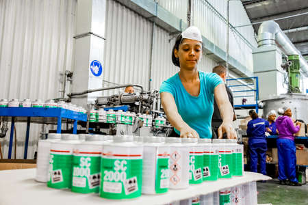 Johannesburg, South Africa - October 19, 2012: Diverse people working on an assembly line in a glue factoryのeditorial素材
