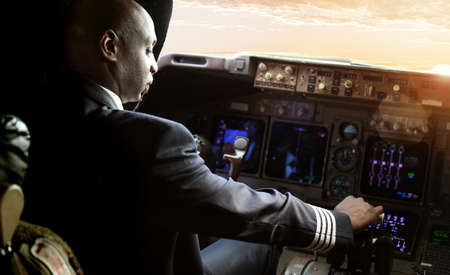 Johannesburg, South Africa - May 08 2012: African Pilot flying a commercial airplane, cockpit view close up of handsのeditorial素材