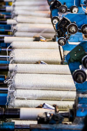 Johannesburg, South Africa - October 16, 2012: Cotton Thread Bobin on a copwinder weft assembly line...