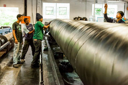 Johannesburg, South Africa - October 19, 2012: Diverse workers inside a rubber and pipe fabrication...