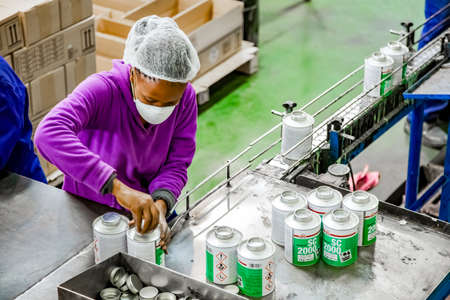 Johannesburg, South Africa - October 19, 2012: Diverse people working on an assembly line in a glue...