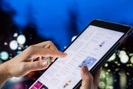 Johannesburg, South Africa - December 10, 2017: Hand pointing finger at digital tablet computer scrolling the internetのeditorial素材