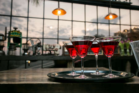 A waiter tray of red cocktails for welcoming drinks at event or partyの写真素材