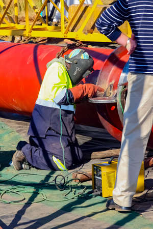 Johannesburg, South Africa - June 09 2010: Tradesman working with welding torch on building site