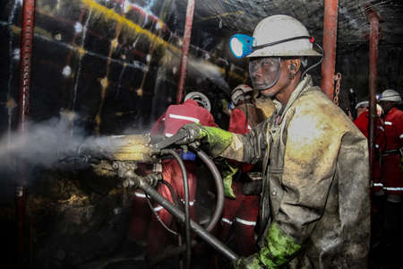 Rustenburg, South Africa, May 23, 2011, Underground Platinum Chrome miners drilling holes in rock for blasting. Holes used for dynamite placementのeditorial素材