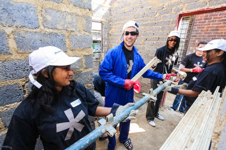 Soweto, South Africa - September 05, 2009: Diverse Community Outreach program helping to build a small affordable house in local townshipのeditorial素材
