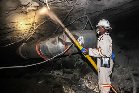 Rustenburg, South Africa, May 23, 2011, Underground Platinum Chrome miners spraying liquid cement for wall and roof reinforcementのeditorial素材