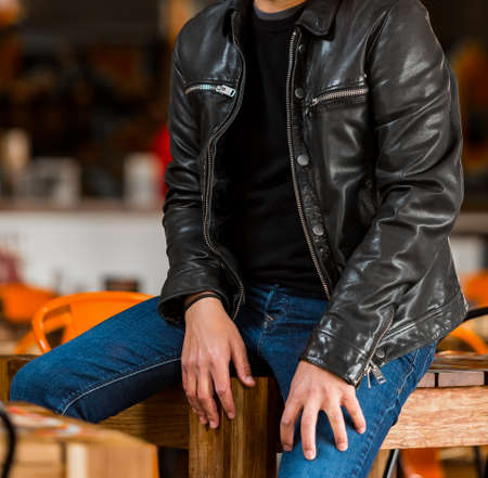 Cropped Head Caucasian Man in casual T-Shirt and leather jacket in a restaurant