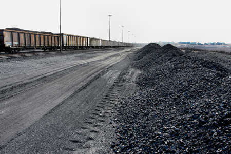 Piles of processed coal next to a rail siding waiting to be put on a train for transporting to a coastal portの写真素材