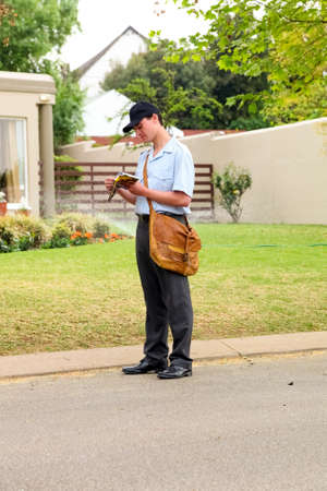 Johannesburg, South Africa - September 11, 2010: Postal Mailman hand delivering mail in a wealthy...