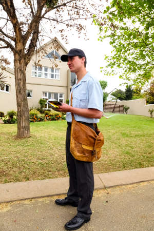 Johannesburg, South Africa - September 11, 2010: Postal Mailman hand delivering mail in a wealthy...