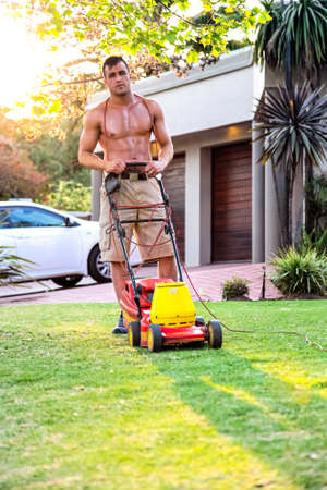 Johannesburg, South Africa - September 10, 2010: Muscular Male mowing a lawn with a lawnmower in wealthy neighborhoodのeditorial素材