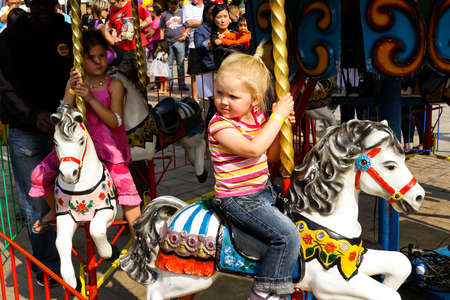 Johannesburg, South Africa - September 22, 2012: Kids riding on fairground carousel merry-go-round out outdoor funfairのeditorial素材