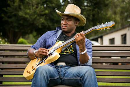 Johannesburg, South Africa - February 19, 2014: African Musician Kunle Ayo, Nigeria playing guitar on a farmのeditorial素材