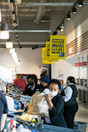 Cape Town, South Africa - December 10, 2020: Grocery Store check-out staff and customers wearing...