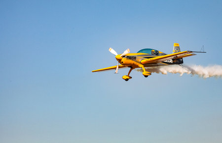 Johannesburg, South Africa - May 22, 2011: Single small propeller airplane performing aerobatics with smoke trailsのeditorial素材