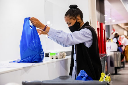 Cape Town, South Africa - December 10, 2020: taff member checking online grocery order for express home delivery service at local Pick n Pay supermarketのeditorial素材