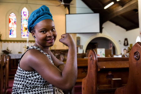 Johannesburg, South Africa - April 27, 2015: Young African girl flexing arm muscles in show of feminist powerのeditorial素材