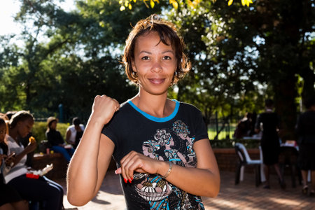 Johannesburg, South Africa - April 30, 2015: Young African girl flexing arm muscles in show of feminist powerのeditorial素材