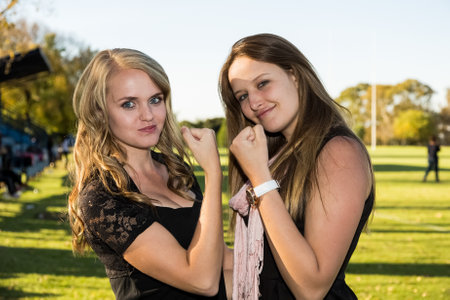 Johannesburg, South Africa - April 30, 2015: Young women flexing arm muscles in show of feminist...