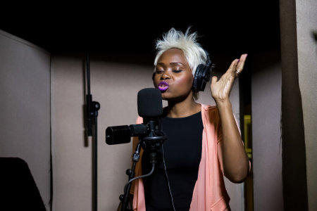 Johannesburg, South Africa - April 28, 2015: Gabriela, Mozambique singer recording vocal part on Afro-pop song in studioのeditorial素材