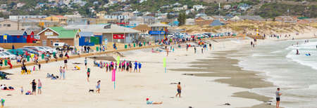 Cape Town, South Africa - February 21, 2021: Swimmers frolicking in the shallow waves of Fish Hoek beachのeditorial素材