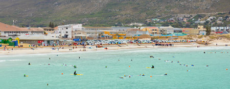 Cape Town, South Africa - February 21, 2021: Swimmers frolicking in the shallow waves of Fish Hoek...