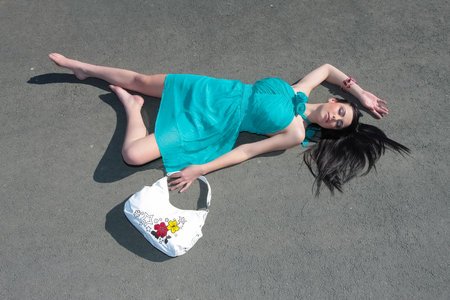 Johannesburg, South Africa - July 30, 2009: Concept of young girl pretending to be dead laying on the road as if a fashion victimのeditorial素材