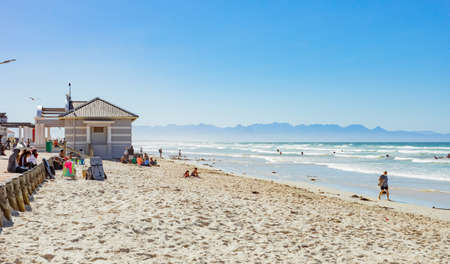 Cape Town, South Africa - March 23, 2021: Surfers and swimmers at Muizenberg beachのeditorial素材