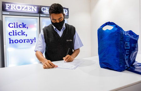 Cape Town, South Africa - December 10, 2020: Staff member checking online grocery order for express...