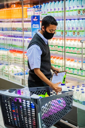 Cape Town, South Africa - December 10, 2020: Staff member picking grocery products from shelf for express home delivery service at local Pick n Pay supermarketのeditorial素材