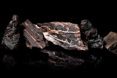 Macro Close up image of raw material Manganese Ore rock isolated on black reflective backgroundの写真素材