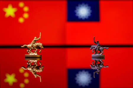 Conceptual image of war between China and Taiwan using toy soldiers and national flags on a reflective backgroundの写真素材