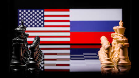 Conceptual image of war between United States and Russia using chess pieces and national flags on a reflective backgroundの写真素材