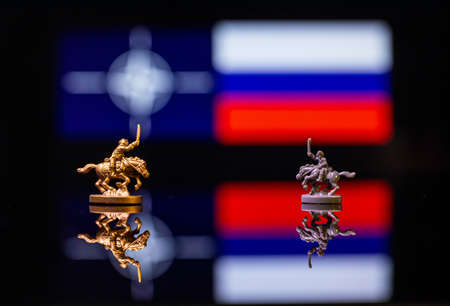 Conceptual image of war between Russia and NATO using toy soldiers and national flags on a reflective backgroundの写真素材