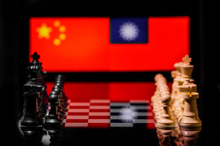 Conceptual image of war between China and Taiwan using chess pieces and national flags on a reflective backgroundの写真素材