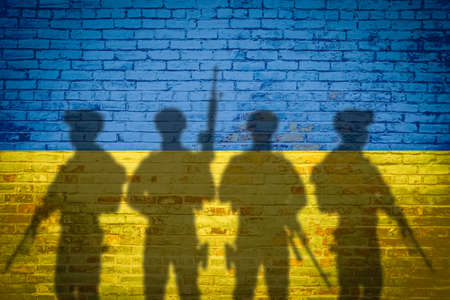 Conceptual image of war between Russia and Ukraine with shadow of soldier against wall with national...