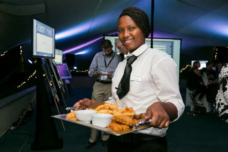 Johannesburg, South Africa - February 16, 2017: Female waitress holding a tray of appetizer canapes