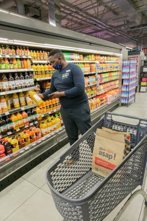 Cape Town, South Africa - September 9, 2021: Staff member picking products from shelf for express...