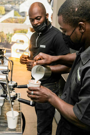 Cape Town, South Africa - April 26, 2022: African Male barista making a coffee at a cafeのeditorial素材