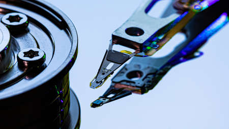 Macro Close up of inside of magnetic Hard Disc Drive with mirror surface and read writer head