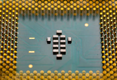 Macro Close up of microchips and pins on Main CPU PC processor circuit board.