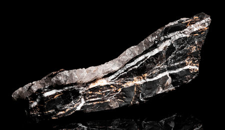 Macro Close up image of raw material Manganese Ore rock isolated on black reflective backgroundの写真素材