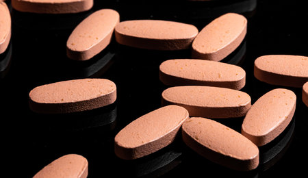 Macro Close up of Multi Vitamin tablet on a reflective black backgroundの写真素材