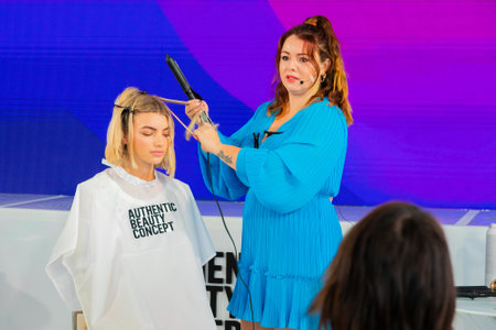Cape Town, South Africa - November 15, 2022: Professional stylist demonstrating on young female model in hair salonのeditorial素材