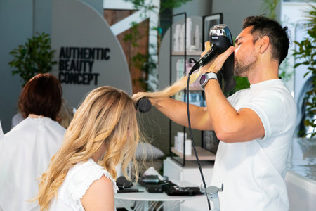 Cape Town, South Africa - November 15, 2022: Professional stylist working on young female model in...