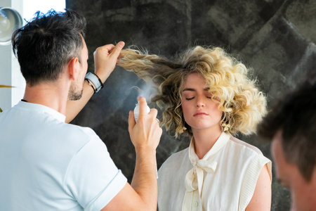 Cape Town, South Africa - November 15, 2022: Professional stylist working on young female model in hair salonのeditorial素材