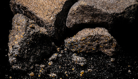 Macro Close up image of raw material Platinum and Chrome Ore rock isolated on black reflective...
