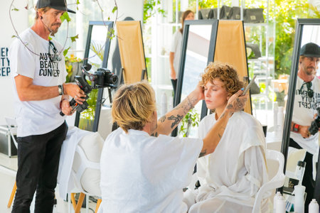 Cape Town, South Africa - November 15, 2022: Professional stylist working on young female model in...