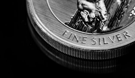 Macro Close up of  Silver Bullion Coin on a black mirror background